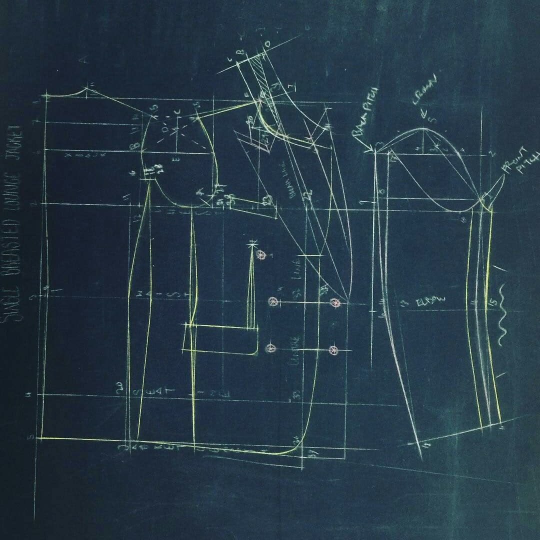 Hand-drafted jacket pattern lines in chalk on dark paper
