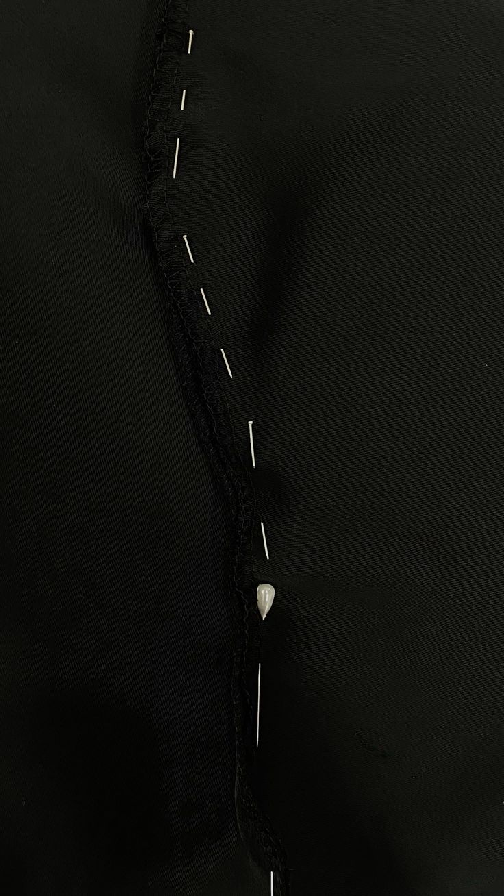 Loose white basting stitches on black fabric